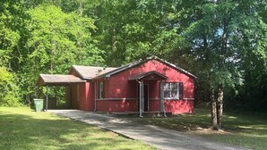 A red building with a porch, a window, and a door. - Serene 3-bedroom house in a pleasant Atlanta neighborhood. (Atlanta)