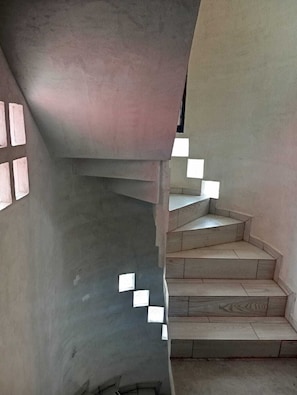 Un escalier en colimaçon avec un mur en béton et un plancher en bois.