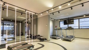 A gym with treadmills, a bench, and exercise equipment. - Piscina Gym & Rooftop no Jardins - Luxo (São Paulo)