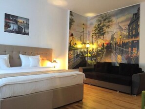 Habitación de hotel con una cama, un sofá y un mural grande con un paisaje urbano en la pared.