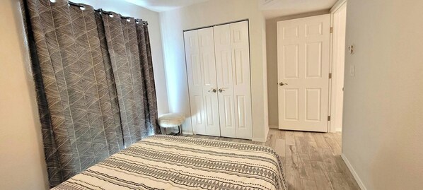 A bedroom with a bed, a chair, a wardrobe, and a door. - Private Bungalow in Downtown Las Vegas (Las Vegas)