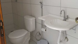 A bathroom with a toilet, bidet, sink, and a mirror. - Pousada Terrissol (São Gonçalo do Amarante)