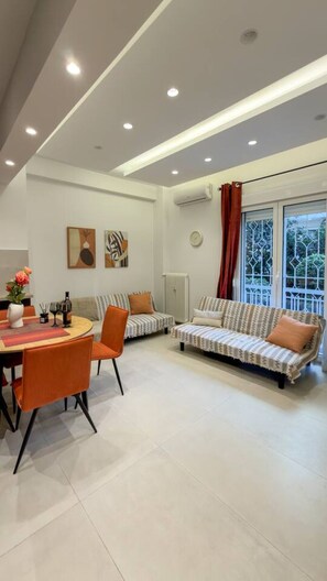 Una sala de estar moderna con comedor, un sofá y un radiador.