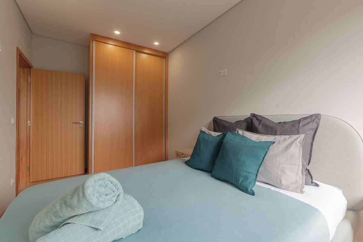 Une chambre à coucher avec un lit, une armoire en bois et une table de chevet.