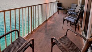 A balcony with wicker chairs, a view of the ocean, and a sunset. - Luxe Tidewater Penthouse sleeps 10 (Panama City Beach)
