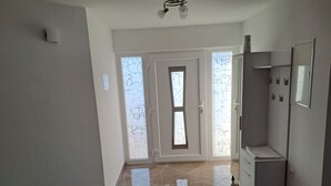 A hallway with a door, a cabinet, and a tiled floor. - Apartment Freya (Karlovac)