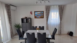 A dining area with a table, chairs, a cabinet, a flag, and a painting. - Apartment Freya (Karlovac)