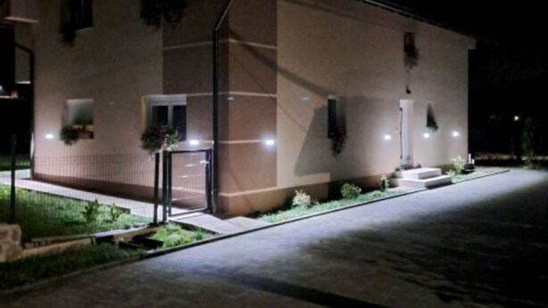 A building with a gated entrance, a small porch, and a well-lit exterior at night. - Apartment Freya (Karlovac)