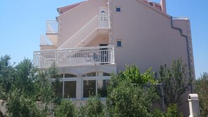 A multi-story building with a balcony, large windows, and a chimney. - Azure Hvar Residence (Hvar)