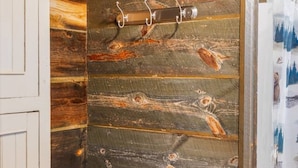 Ein rustikaler Raum mit einer Holzwand, einer Tür und einem Stuhl.