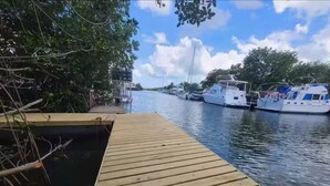 Un muelle de madera que se extiende sobre aguas tranquilas, con barcos amarrados cerca.