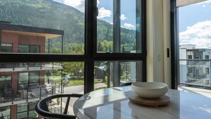 Ein Zimmer mit großem Fenster, einem Tisch mit Schüssel und einem Stuhl.