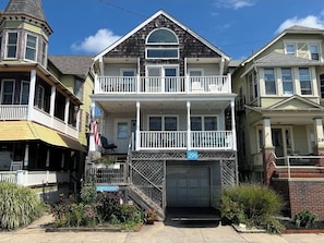 A two-story house with a balcony, a garage, and a small porch. - Breathe in Ocean Air & Make Lasting Memories at this Water Front Property (Ocean Grove)