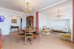 A dining area with a round table, chairs, and a chandelier. - Classic French & Modern Comfort in Cannes (Cannes)