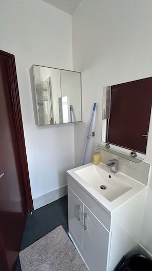 A bathroom with a white sink, a mirror, a towel rack, and a door. - House - Sleeps 10 - Honor Oak Park Station 2 Mins Walk (London)