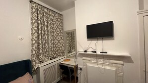 A bedroom with a bed, a desk, a radiator, and a TV mounted on the wall. - House - Sleeps 10 - Honor Oak Park Station 2 Mins Walk (London)