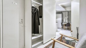 Ein modernes Interieur mit begehbarem Kleiderschrank, Essbereich und einer Sitzecke mit Glastisch.