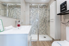 A modern bathroom with a glass-enclosed shower, a white sink, and a toilet. - Apartment in the Historic Centre of Malaga (Málaga)