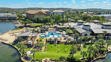 Um resort com piscina, quadras de tênis e um píer.