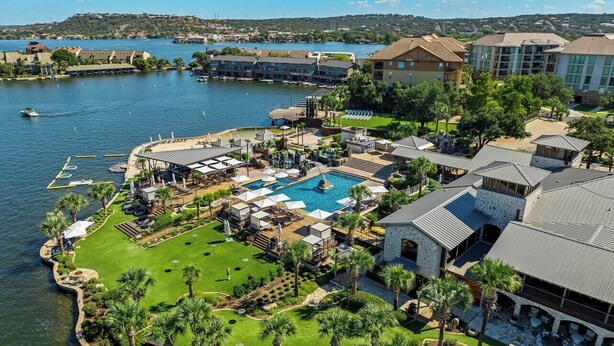 Eine Luftaufnahme eines Resorts mit großem Pool, mehreren Gästezimmern und einer Marina.