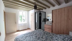 Ein Schlafzimmer mit Bett, Kleiderschrank, Heizkörper und Fenster.