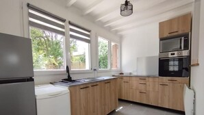 Eine Küche mit Holzschränken, einem Einbauofen und einem Kühlschrank.