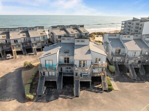A beachfront residential complex with multiple buildings, balconies, and a parking area. - Ocean Views & Balconies | Tide of Your Life (North Topsail Beach)