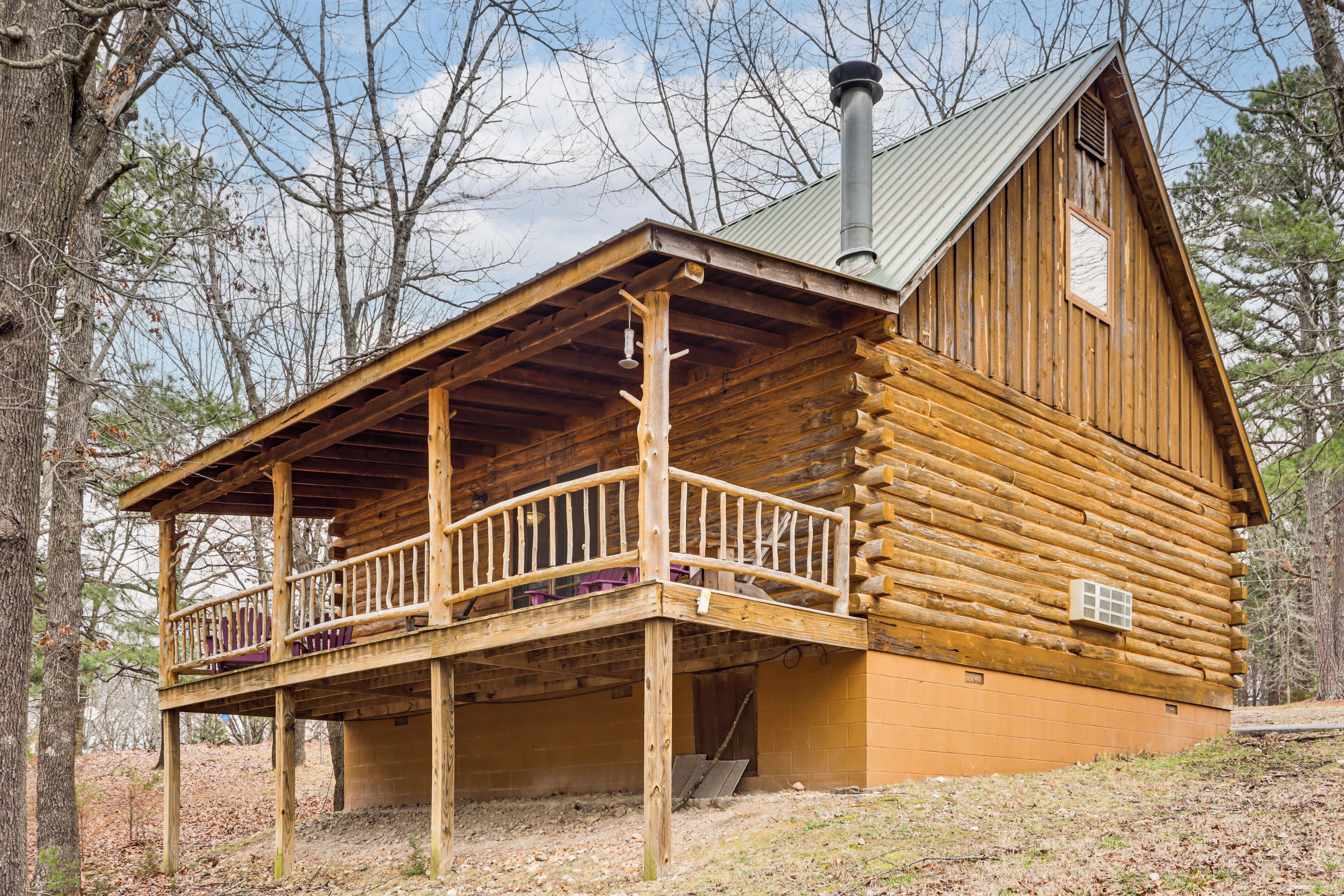 A log cabin with a balcony, a chimney, and a window.