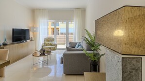 A modern living room with a flat-screen TV, a sofa, a coffee table, and a potted plant. - #356 Vale de Parra | Pool & Nature (Albufeira)