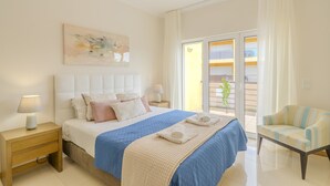A bedroom with a bed, nightstands, a chair, a balcony, and a painting. - #356 Vale de Parra | Pool & Nature (Albufeira)