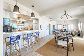 A spacious kitchen with a large island, bar stools, and pendant lighting. - Luxury Beachfront Home: Pool, Large Groups, Boat, Water Sports (San Pedro)