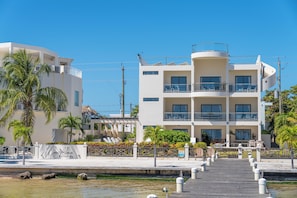 A multi-story hotel with balconies, a poolside area, and a waterfront view. - Luxury Beachfront Home: Pool, Large Groups, Boat, Water Sports (San Pedro)