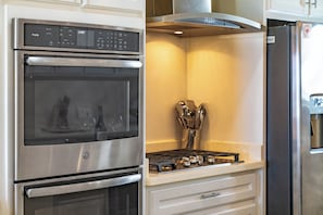 A kitchen with a stainless steel oven, a gas stove, and a refrigerator. - Luxury Beachfront Home: Pool, Large Groups, Boat, Water Sports (San Pedro)