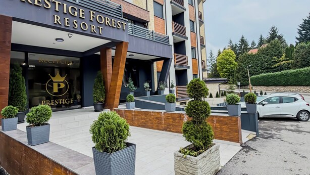 Un bâtiment moderne sur lequel on peut lire l’inscription : « PRESTIGE FOREST RESORT ».