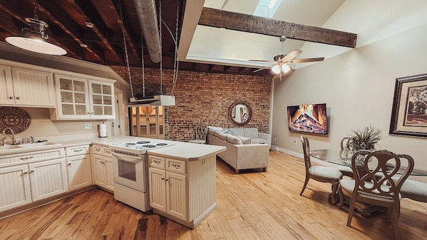 Una cocina con armarios de madera, una isla central y una zona de comedor con un sofá y sillas.
