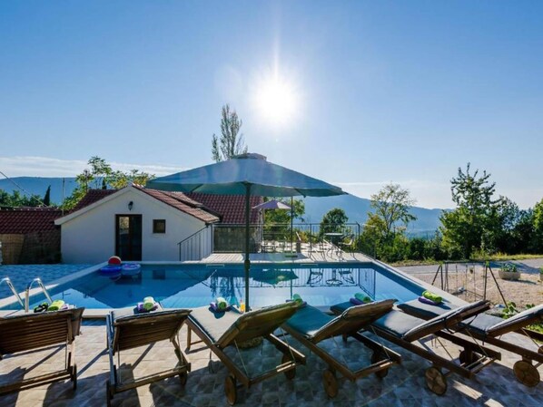 A swimming pool with lounge chairs and a small building with a red roof. - Rustic Villa in Gruda With Private Pool (Konavle)
