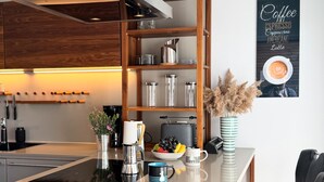 Una cocina moderna con armarios de madera, electrodomésticos de acero inoxidable y un cuadro con motivos de café.