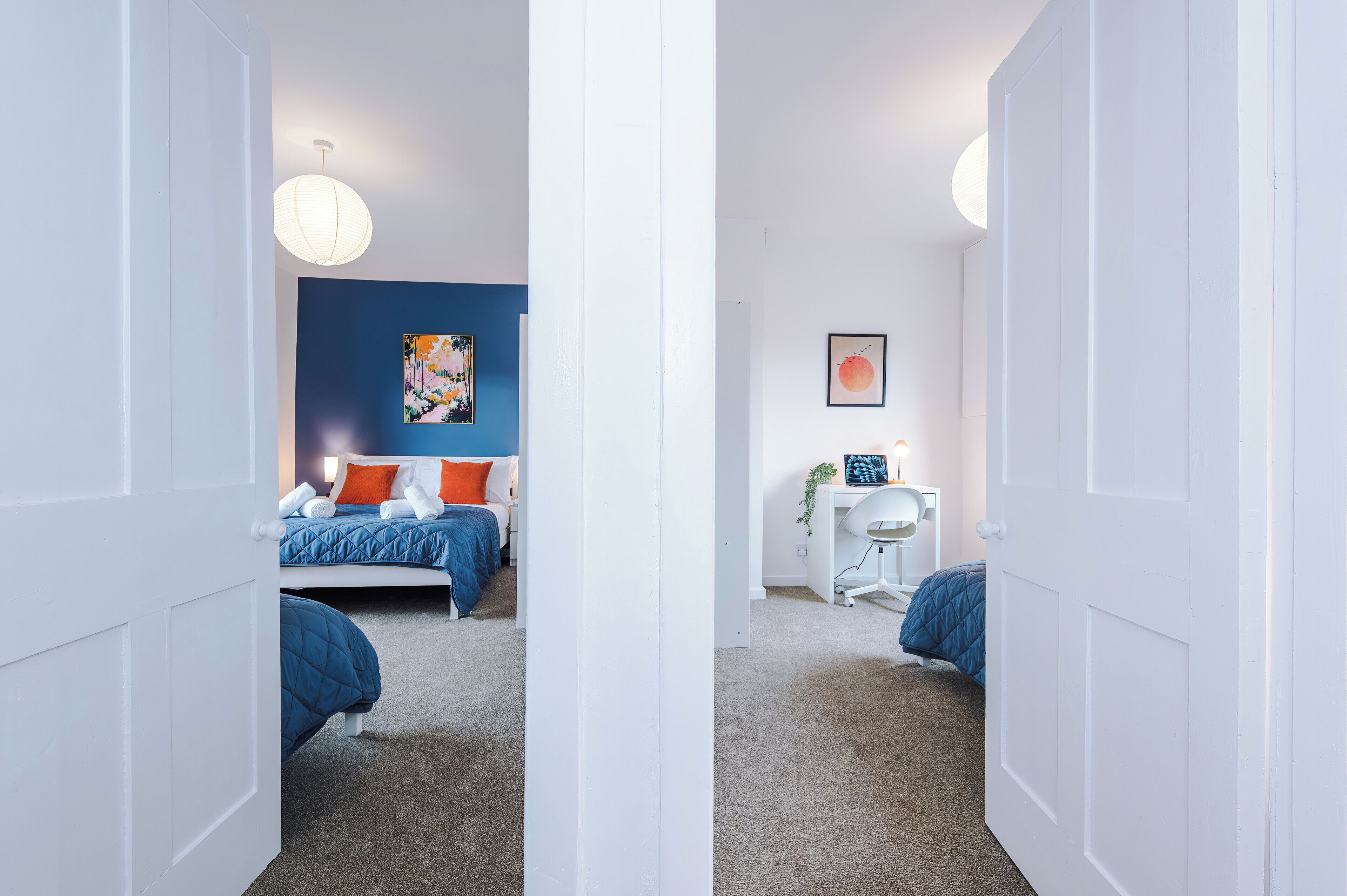 A bedroom with a bed, a desk, and a chair.