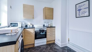 Eine moderne Küche mit Mikrowelle, Backofen und Holzschränken.