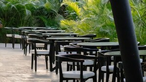 An outdoor dining area with tables and chairs, surrounded by lush greenery and hanging light fixtures. - New Studio @ Xibalba | Private Pool + King Bed (Tulum)