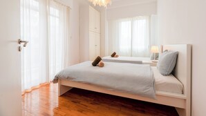 A bedroom with a bed, a mirror, a bedside table, and a hanging light fixture. - Family, Sunny safe & cozy choice 1 Km Athens 3 bedrms, 120 sq.m  1300 sq.ft 1st (Kesariani)