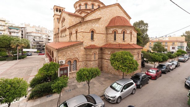 A stone church with a red-tiled roof, surrounded by parked cars and trees. - Family, Sunny safe & cozy choice 1 Km Athens 3 bedrms, 120 sq.m  1300 sq.ft 1st (Kesariani)