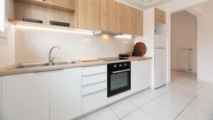 A modern kitchen with white cabinetry, a black oven, and a wooden countertop. - Family, Sunny safe & cozy choice 1 Km Athens 3 bedrms, 120 sq.m  1300 sq.ft 1st (Kesariani)