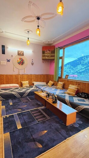 Una habitación acogedora con cama, sofá, piso de madera, ventilador de techo y ventana con vistas.