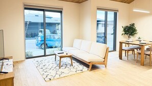 Uma sala de estar moderna com sofá, mesa de centro e área de jantar.