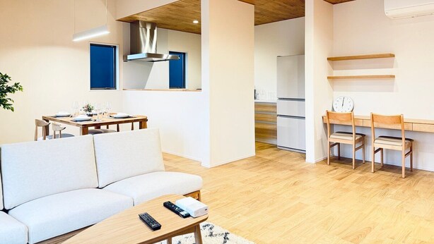 Uma sala de estar moderna com um sofá, uma mesa de centro e uma área de jantar com uma mesa e cadeiras.