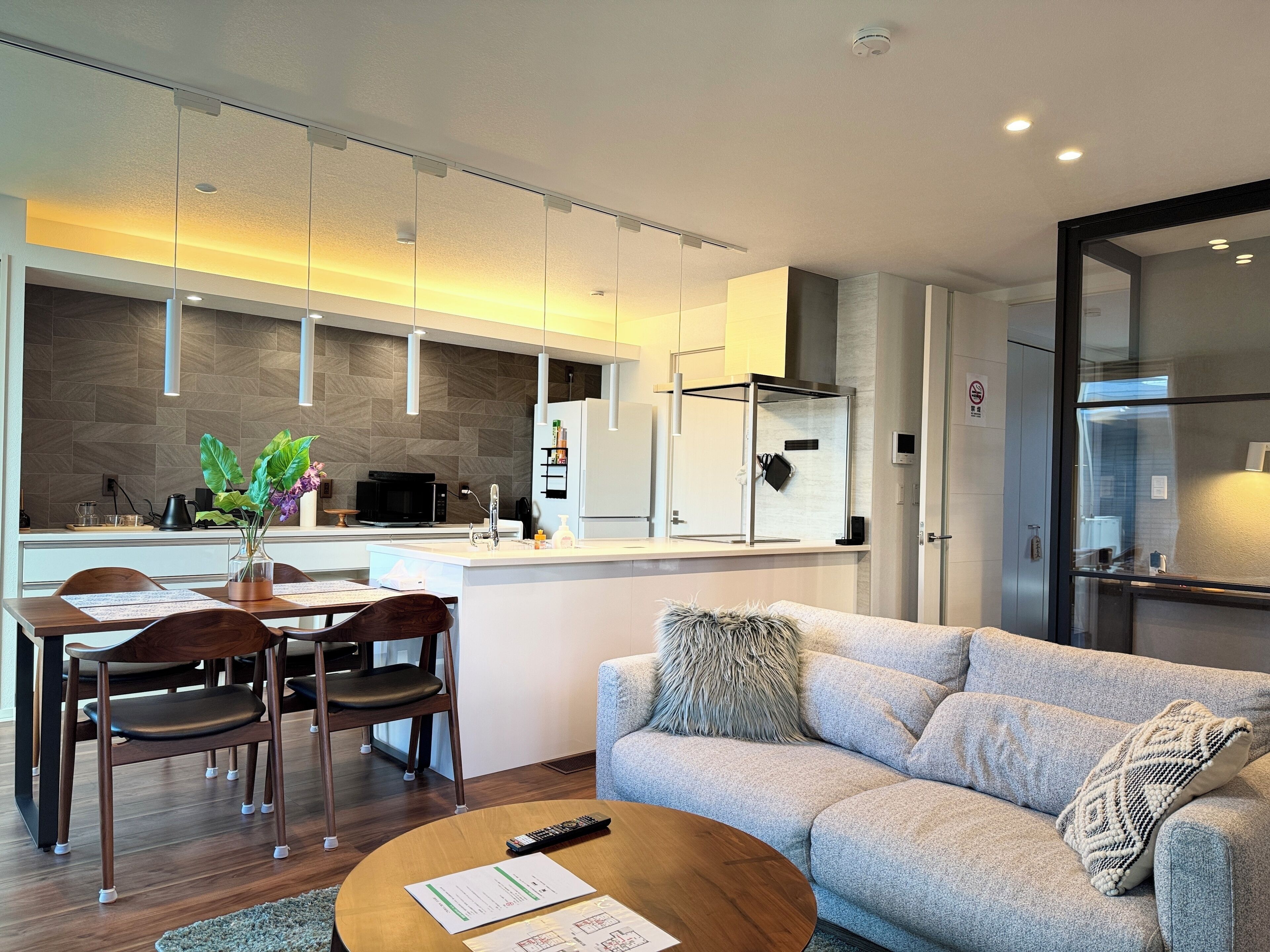 Une cuisine moderne avec un coin repas, un canapé et une table basse.