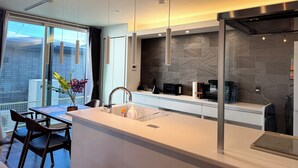 Una cocina moderna con una isla grande, electrodomésticos integrados y vistas a la ciudad.