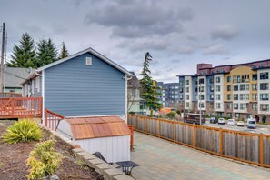 A residential backyard with a blue shed, a wooden fence, and a paved patio. - Work & Explore Downtown Tacoma! Convenient Condo (Tacoma)