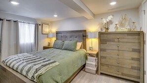 Una camera da letto con un letto, comodini, una cassettiera e lampade a parete.